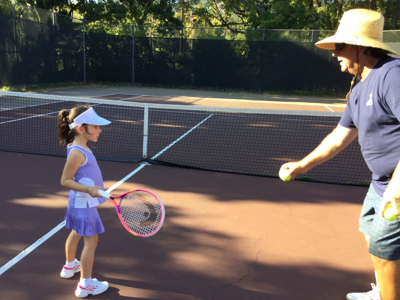 Young Gabi at the net with Coach Jay feeding balls