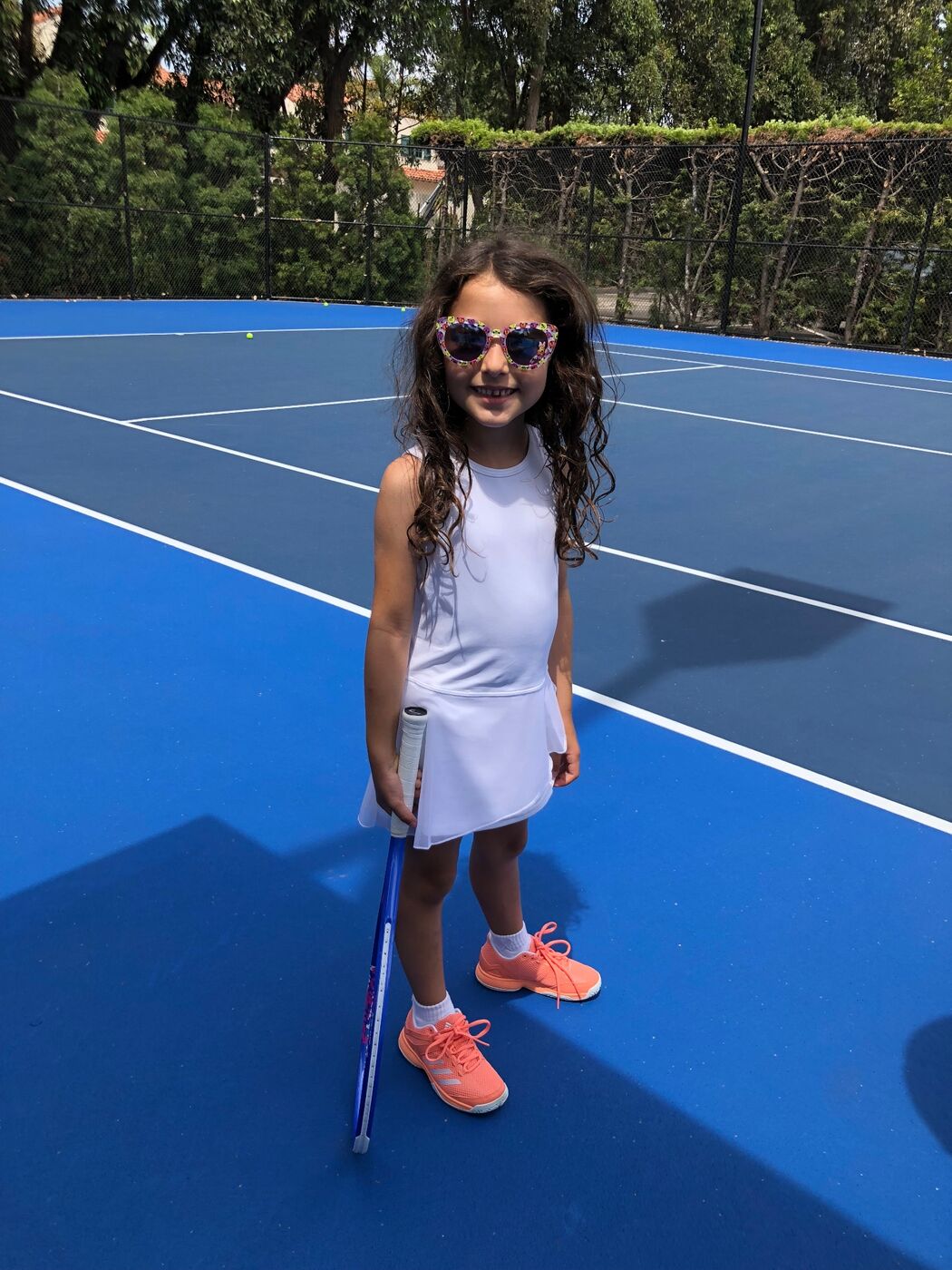 Gabi standing tall with racket on a blue court